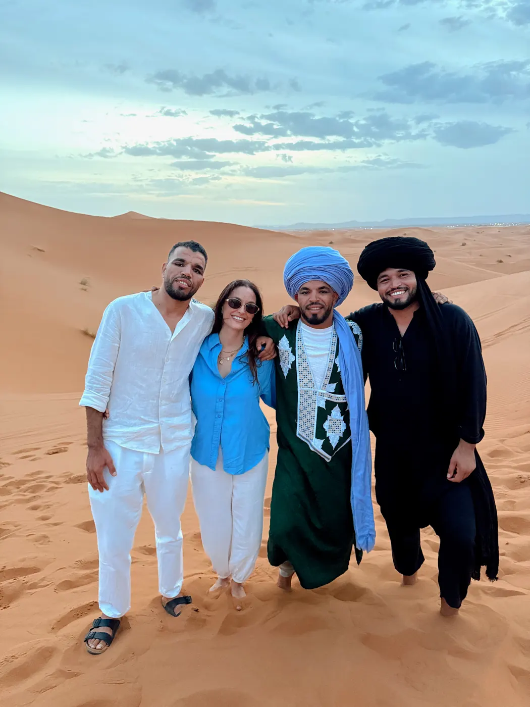 Travelers and guides standing together on the Erg Chebbi dunes