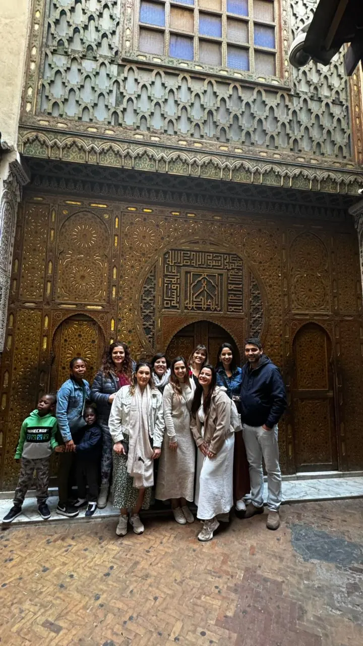 Travelers visiting a carved doorway in the Fes medina