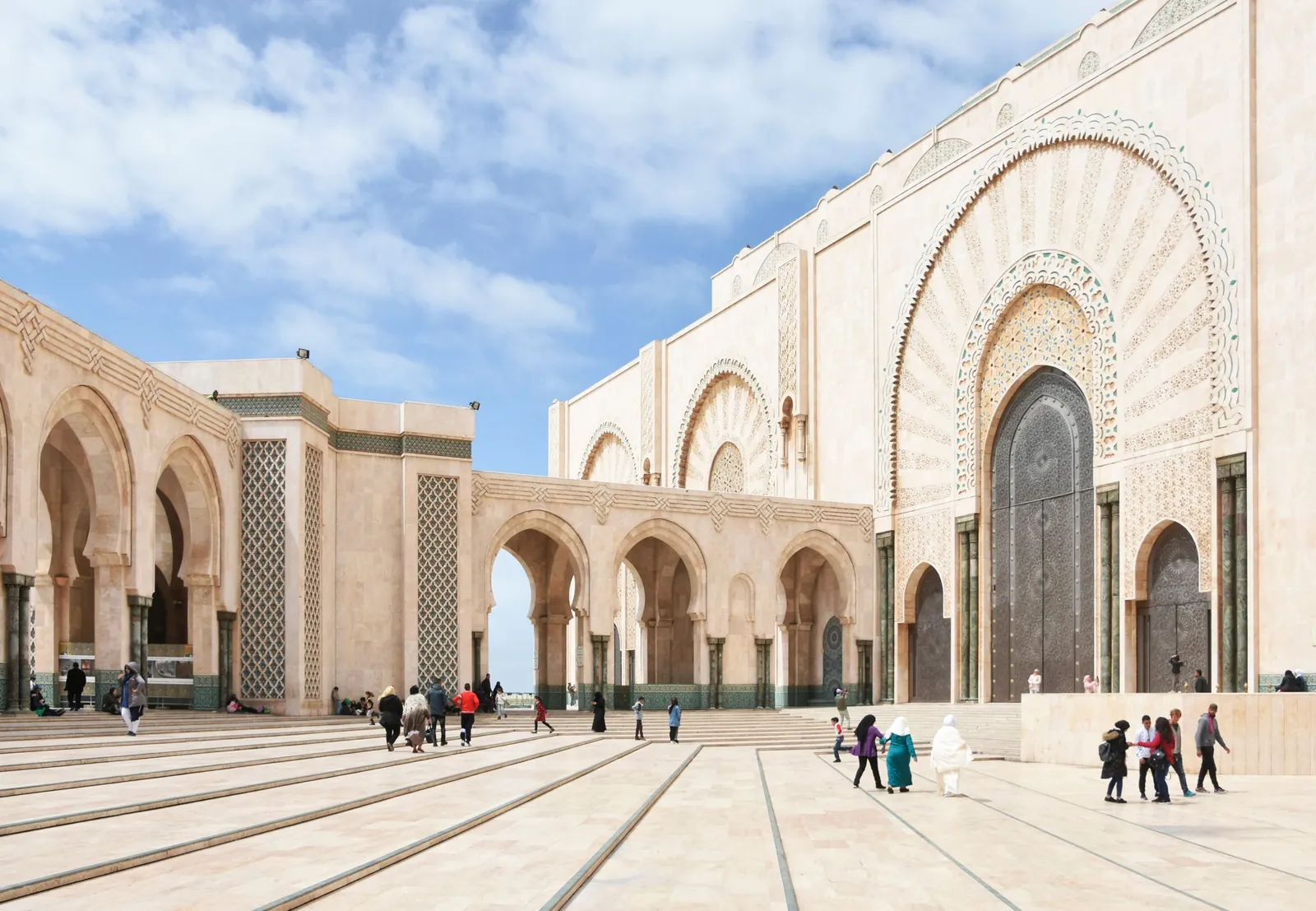 Visitors crossing the courtyard outside Hassan II Mosque in Casablanca
