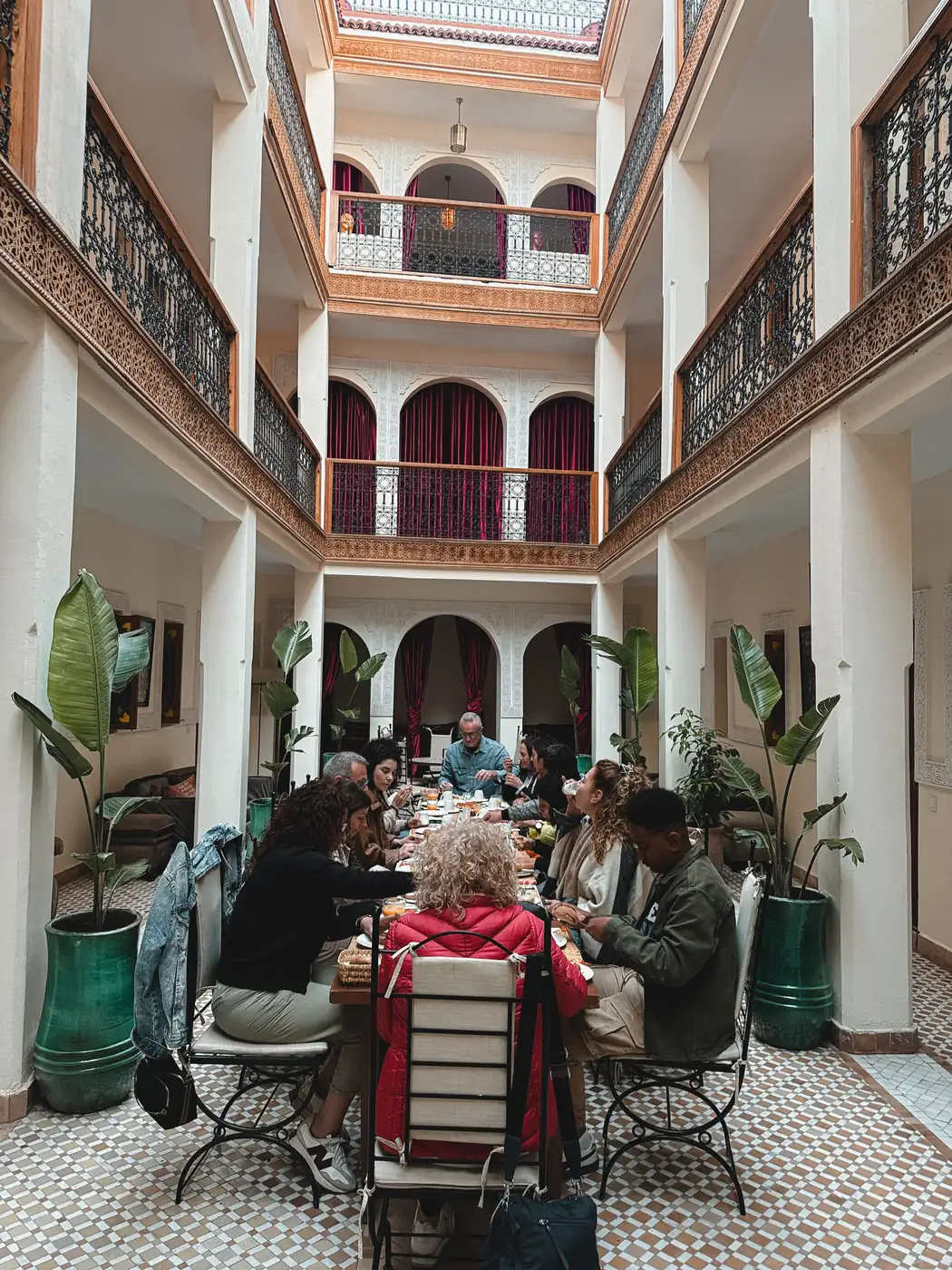Guests seated around tables in a traditional Marrakech riad courtyard