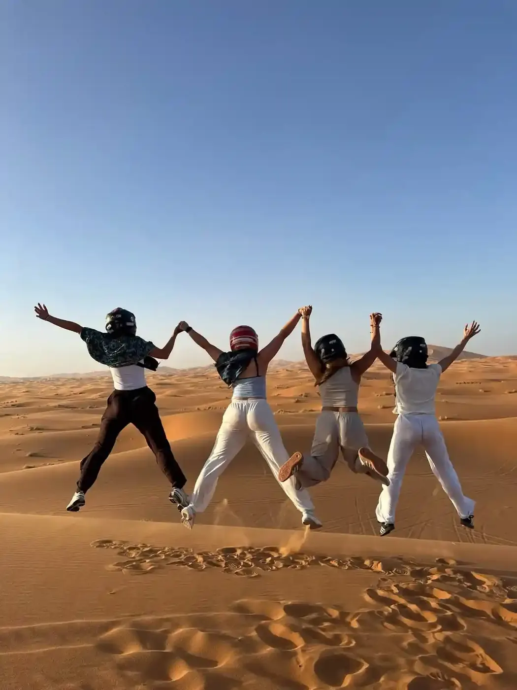 Travelers jumping on an Erg Chebbi sand dune